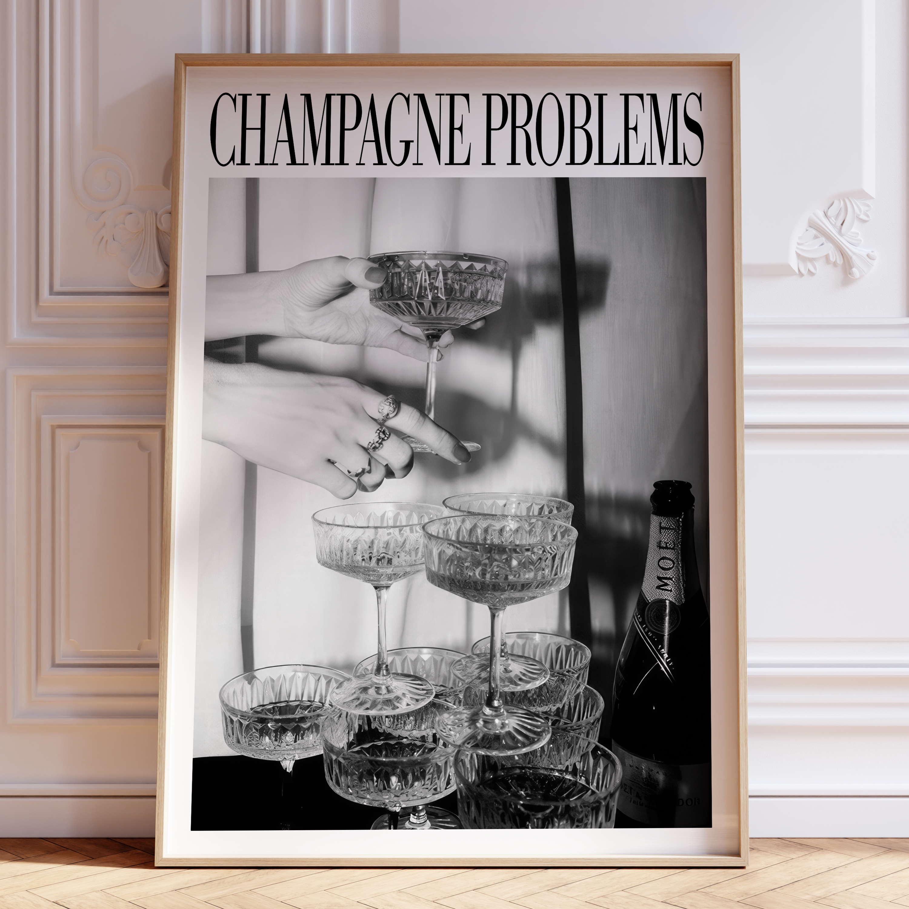 Framed artwork with 'Champagne Problems' text and a black and white photo of hands holding glasses and a bottle.